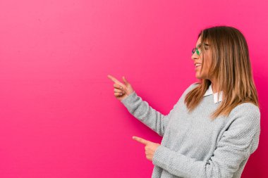 Genç otantik karizmatik gerçek insanlar kadın bir duvara karşı heyecanlı forefingers uzakta işaret.