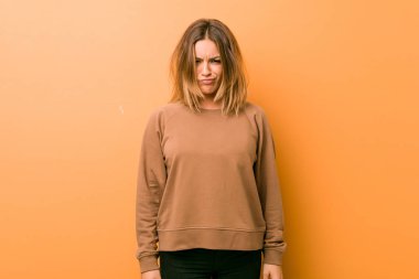 Bir duvara karşı genç otantik karizmatik gerçek insanlar kadın yanakları darbeler, yorgun ifade vardır. Yüz ifadesi kavramı.