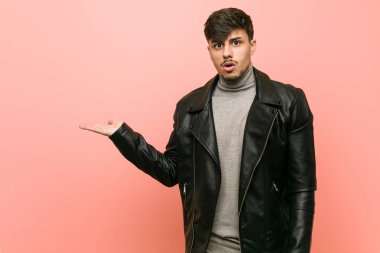 Deri ceket giyen genç İspanyol adam avuç içinde kopya alanı tutarak etkilendim.