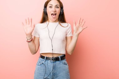 Genç beyaz kadın bir zafer ya da başarı kutlayan müzik dinlemek