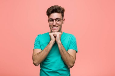 Genç serin kafkas adam çene altında ellerini tutar, bir kenara mutlu bakıyor.