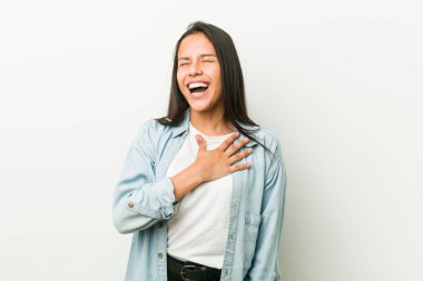 Genç İspanyol kadın yüksek sesle göğüs üzerinde el tutarak gülüyor.