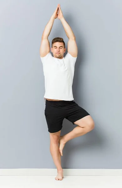 Young caucasian man practicing yoga indoor — Stock Photo, Image