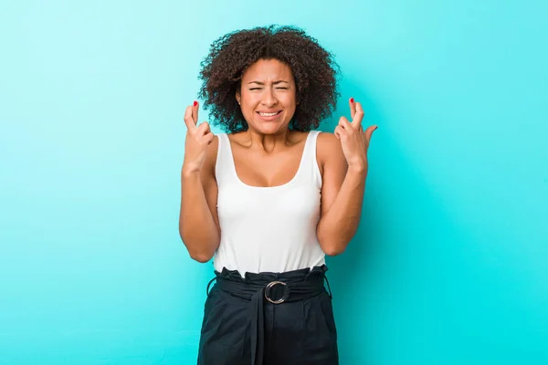 stock image Young african american woman crossing fingers for having luck