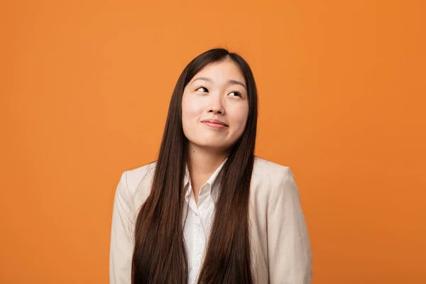 Young business chinese woman dreaming of achieving goals and purposes