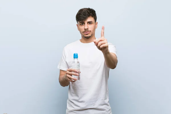 Joven Hispano Sosteniendo Una Botella Agua Mostrando Número Uno Con — Foto de Stock