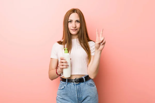 Jonge Blanke Vrouw Houdt Een Crème Fles Met Nummer Twee — Stockfoto