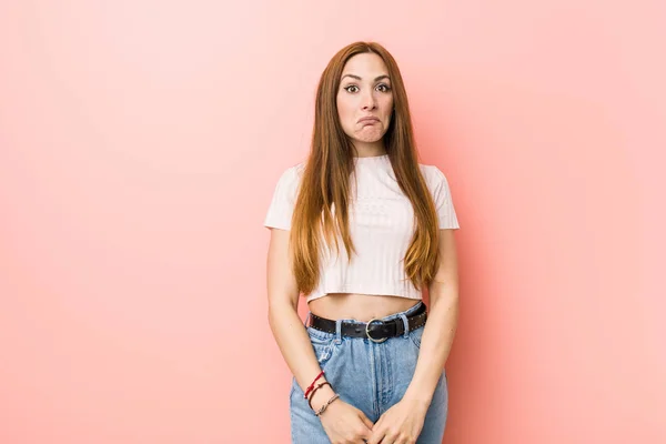 Young Redhead Ginger Woman Pink Wall Shrugs Shoulders Open Eyes — Stock Photo, Image