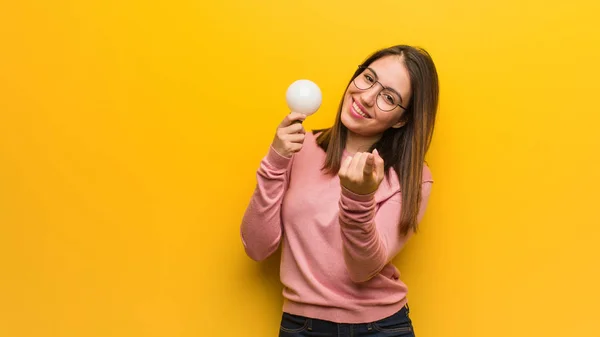 Wanita Cantik Muda Memegang Bola Lampu Mengundang Untuk Datang — Stok Foto