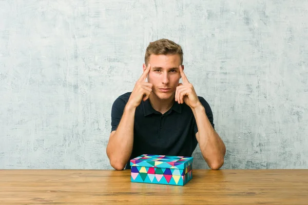 Young Caucasian Man Holding Gift Box Table Focused Task Keeping — Stock Photo, Image