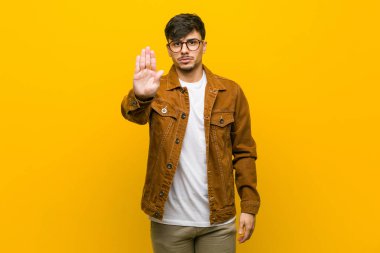 Genç İspanyol rahat adam uzanmış el ile dur işareti gösteren ayakta, sizi engelleyen.