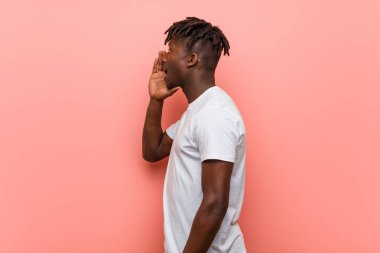 Genç Afrikalı siyah adam bağırıyor ve açık ağız yakınında palmiye tutarak.