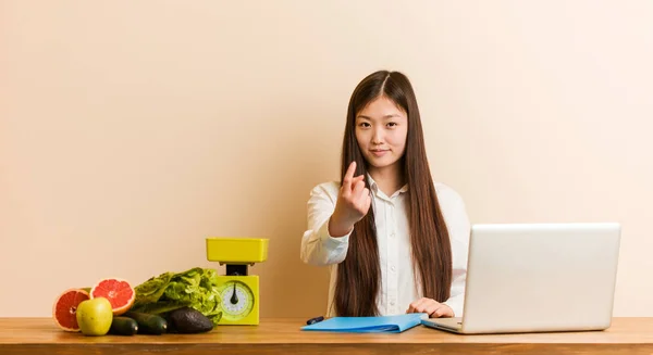 Young Nutritionist Chinese Woman Working Her Laptop Pointing Finger You — Zdjęcie stockowe