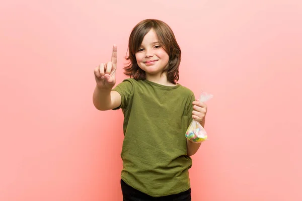 Μικρό Αγόρι Καυκάσιος Κρατώντας Καραμέλες Δείχνοντας Νούμερο Ένα Δάχτυλο — Φωτογραφία Αρχείου
