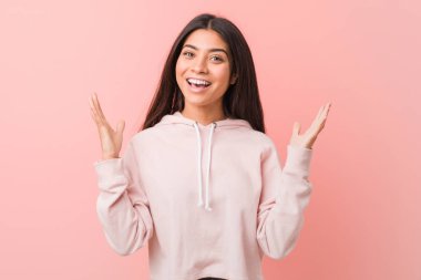 Genç güzel arap kadın rahat bir spor bir zafer ya da başarı kutluyor bakmak giyen, o şaşırır ve şok.