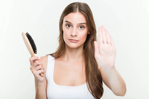 Young Caucasian Woman Holding Hair Brush Standing Outstretched Hand Showing — Stockfoto
