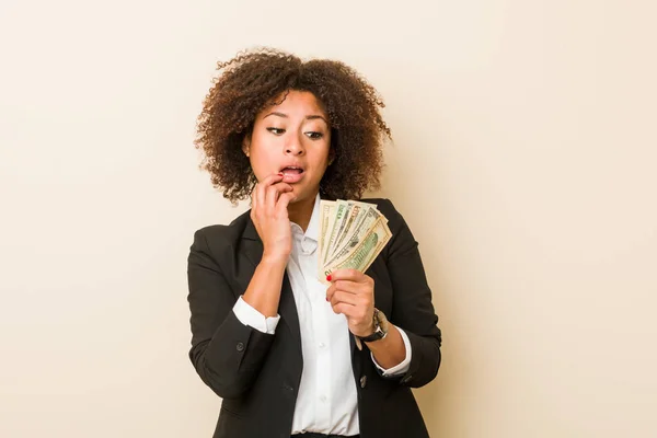 Mujer Afroamericana Joven Sosteniendo Dólares Relajado Pensando Algo Mirando Espacio — Foto de Stock