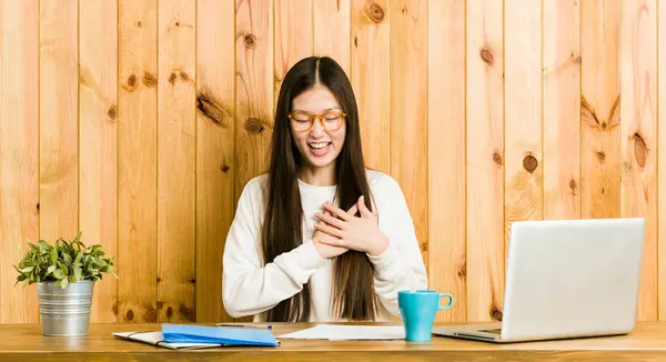 Jovem Chinesa Estudando Sua Mesa Rindo Mantendo Mãos Coração Conceito — Fotografia de Stock