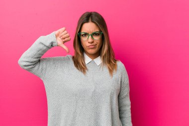 Genç otantik karizmatik gerçek insanlar kadın bir duvara karşı bir nefret jest gösteren, başparmak aşağı. Anlaşmazlık kavramı.