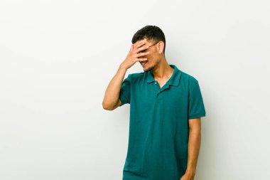 Genç İspanyol adam parmakları ile kameraya göz kırptı, yüz kapsayan utandım.