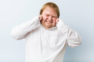 Genç otantik kızıl saçlı şişman adam elleri ile kulakları kapsayan.