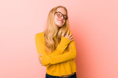 Sevimli genç kadın kucaklar, kaygısız ve mutlu gülümseyen.