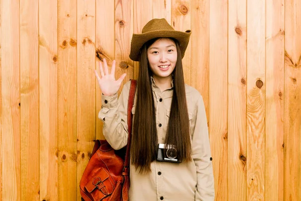 年轻的中国女旅行家高兴地微笑着 用手指展示着第五位 — 图库照片