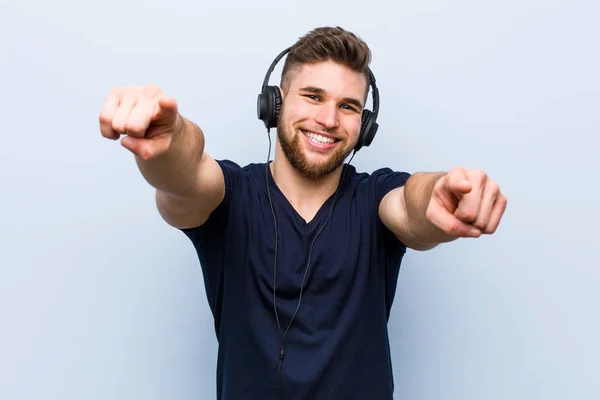 Jovem Caucasiano Ouvindo Música Sorrisos Alegres Apontando Para Frente — Fotografia de Stock