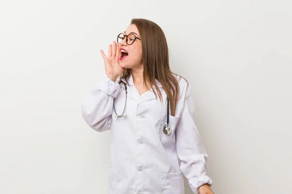 Jonge Dokter Vrouw Tegen Een Witte Muur Schreeuwen Vasthouden Palm — Stockfoto