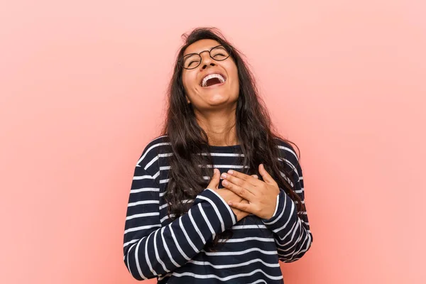 Young intellectual indian woman laughing keeping hands on heart, concept of happiness.