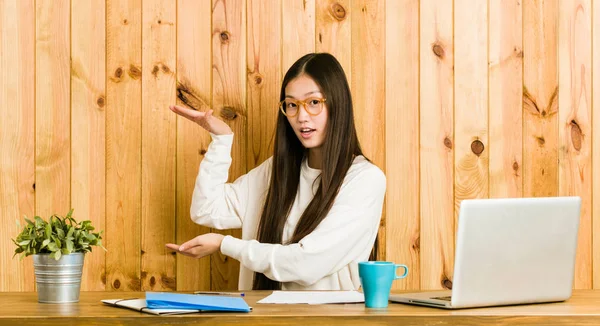 Joven Mujer China Estudiando Escritorio Sorprendido Sorprendido Sosteniendo Espacio Copia — Foto de Stock