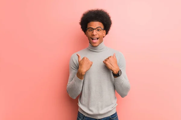 年轻的非洲裔美国人在粉红色的墙上惊讶 感觉成功和繁荣 — 图库照片