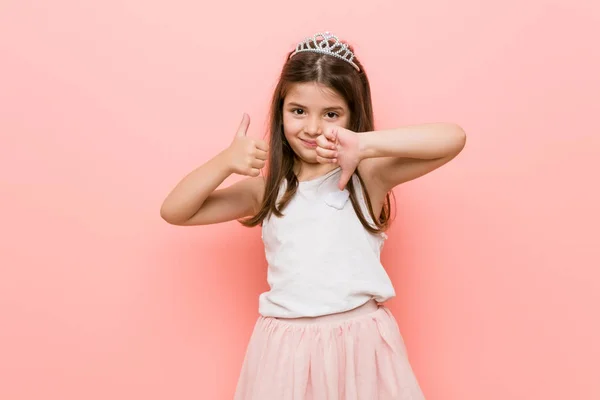 小女孩穿着公主的样子显示竖起大拇指向下 难选概念 — 图库照片