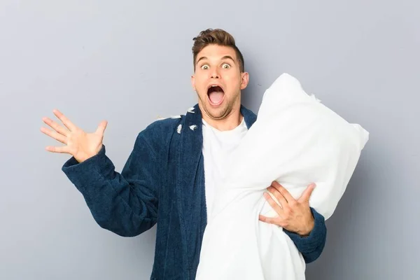 Young Man Wearing Pijama Holding Pillow Celebrating Victory Success — Stock Fotó