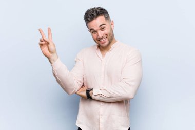 Genç yakışıklı serin adam neşeli ve kaygısız parmakları ile bir barış sembolü gösteren.