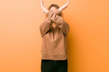 Genç otantik karizmatik gerçek insanlar kadın bir duvara karşı iki kol çapraz tutarak, inkar kavramı.