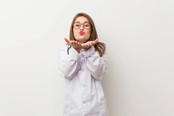 Jonge Dokter Vrouw Tegen Een Witte Muur Vouwen Lippen Het — Stockfoto