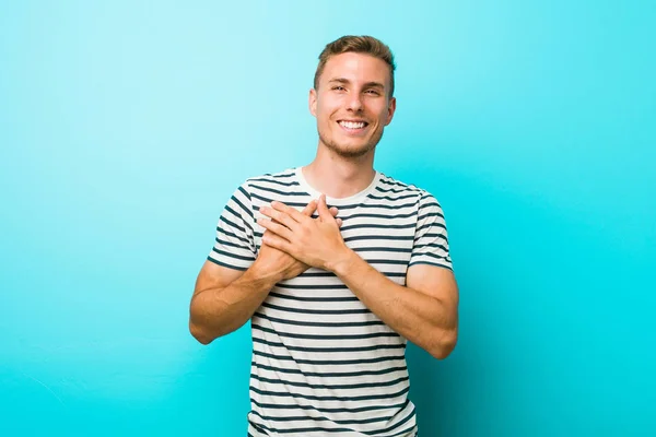 Jonge Blanke Man Tegen Een Blauwe Muur Lachen Houden Handen — Stockfoto