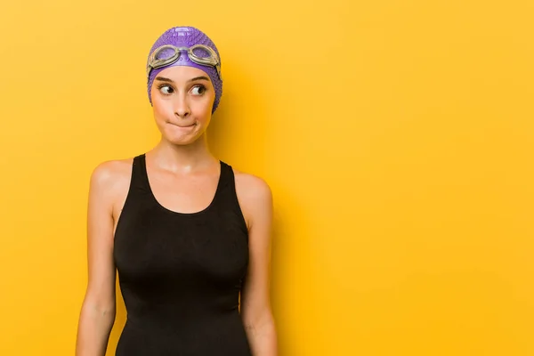 Young swimmer caucasian woman confused, feels doubtful and unsure.