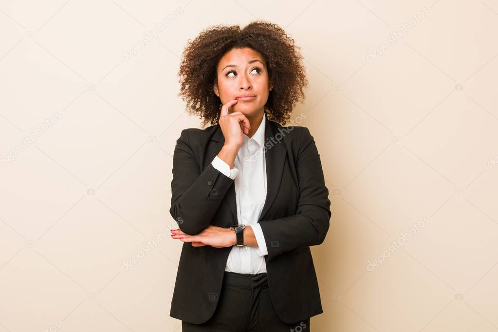 Young business african american woman looking sideways with doubtful and skeptical expression.