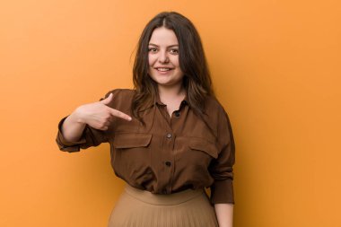 Genç kıvrımlı Rus kadın kişi bir gömlek kopyalama alanı, gurur ve kendinden emin elle işaret