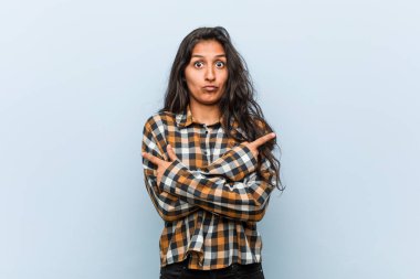 Genç serin hintli kadın yan lara işaret ediyor, iki seçenek arasında seçim yapmaya çalışıyor.