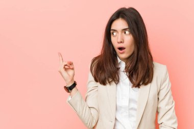 Yan gösteren pembe bir arka plan karşı genç esmer iş kadını