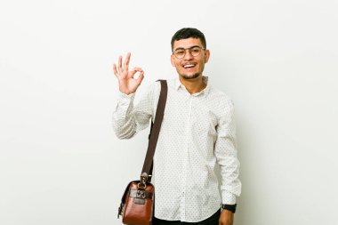 Genç İspanyol rahat iş adamı bir göz kırpmak ve el ile tamam bir jest tutar.