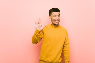 Genç İspanyol adam bir göz kırpıyor ve el ile tamam bir jest tutar.