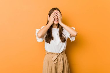 Kafkasyalı genç kadın elleriyle gözlerini kapatıyor, gülümseyerek bir sürpriz bekliyor..