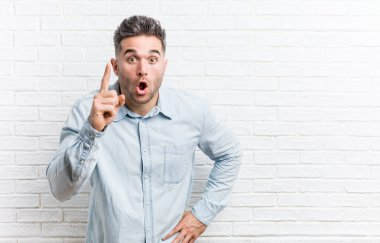Bir fikir, ilham kavramı olan bir tuğla duvara karşı genç yakışıklı adam.