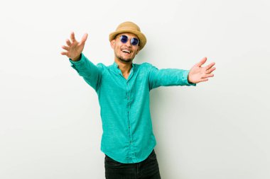 Yazlık kıyafetler giyen genç İspanyol adam kameraya sarılarak kendinden emin hissediyor..