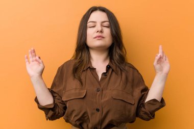 Genç kıvrımlı Rus kadın zor iş gününden sonra rahatlatır, o yoga yapıyor.