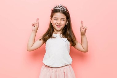 Küçük kız bir prenses giyen şans için parmakgeçiş bakmak